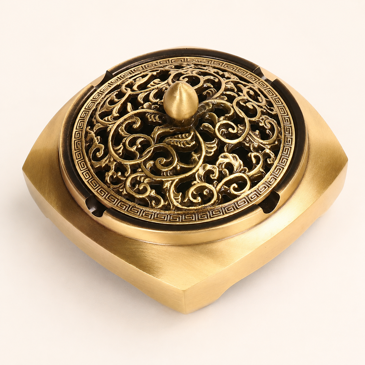 Close-up of ornate brass incense burner lid with carved floral pattern