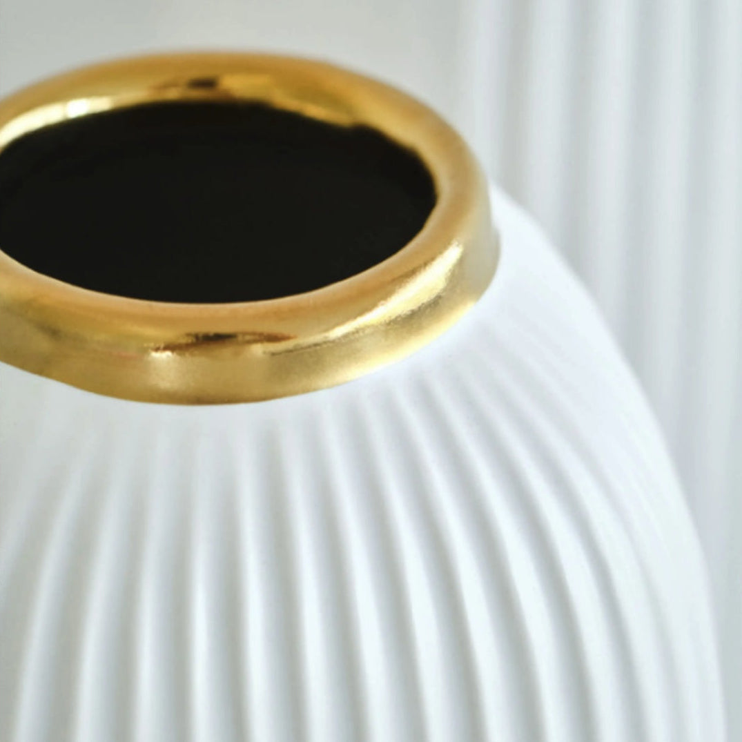 Close up of gold rim on ribbed white ceramic vase