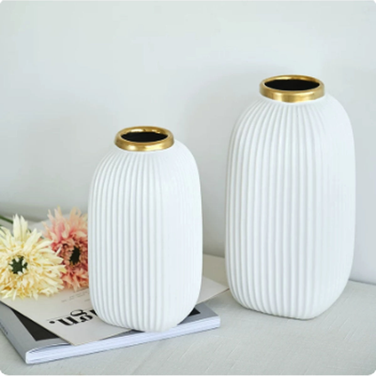 White ribbed ceramic vases with gold rims styled as modern table decor