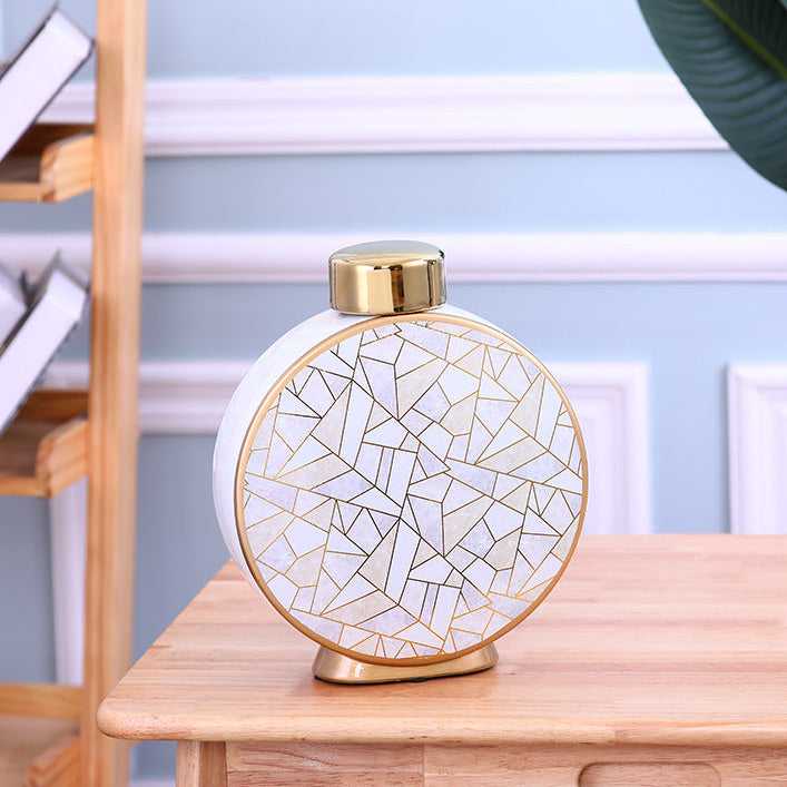 Medium round ceramic decorative vase with gold crackle design on a wooden table