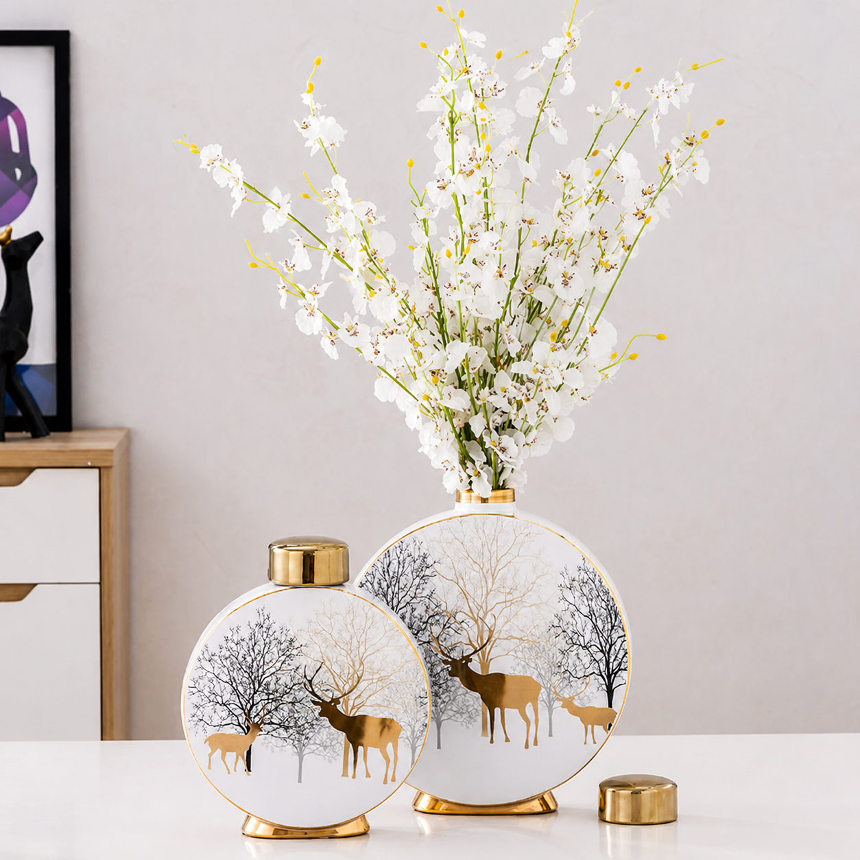 Round ceramic vase set styled with white flowers and gold accents