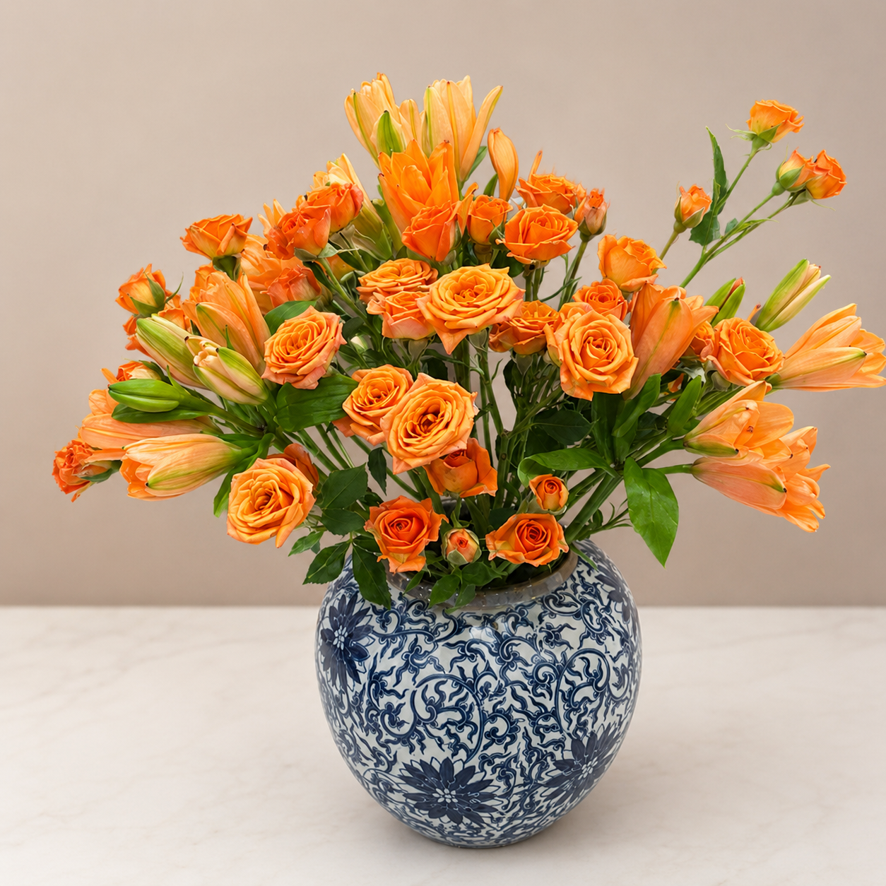 Blue and white ceramic vase with orange flowers on clean neutral background