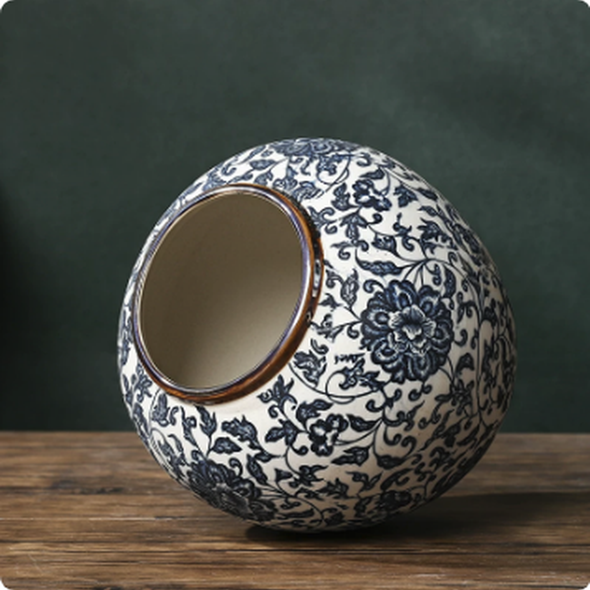 Blue and white ceramic vase tilted on wooden table