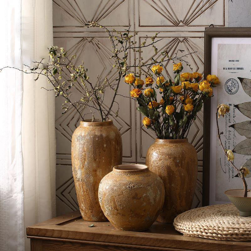 Rustic brown textured ceramic vases displayed together in a warm interior