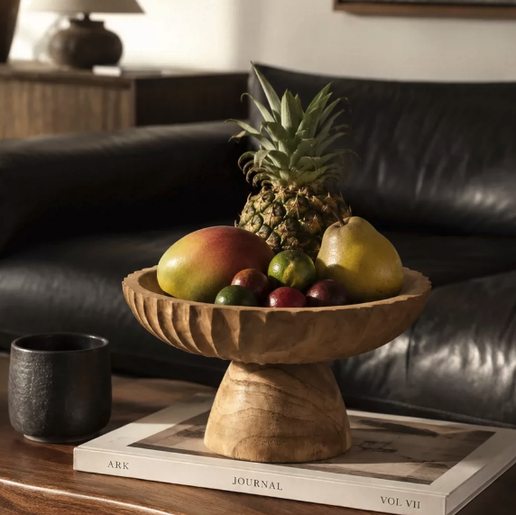 Rustic wooden pedestal bowl with mixed fruit styled on a coffee table