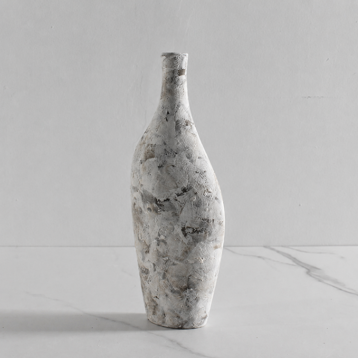 Tall gray stone effect ceramic decorative vase on a marble surface