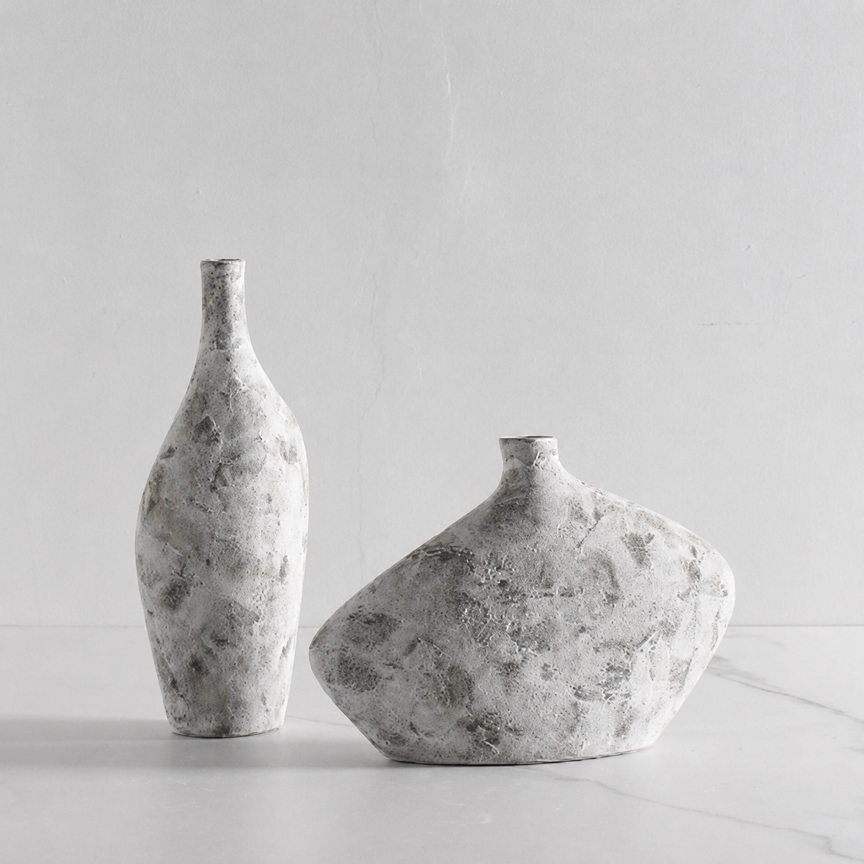 Short and tall sculptural gray textured ceramic vases displayed together