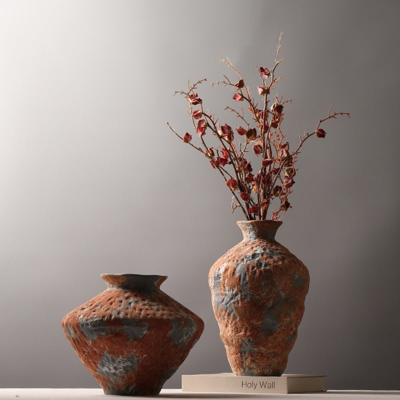 Orange gray textured ceramic vases displayed with decorative dried branches