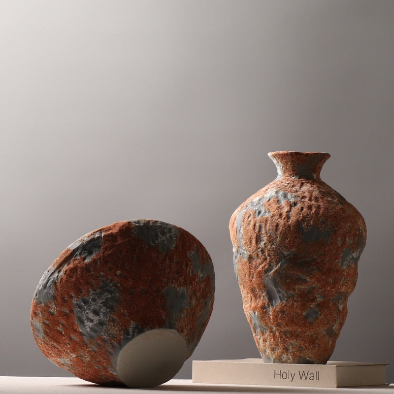Short round and tall sculptural orange gray ceramic vases displayed together