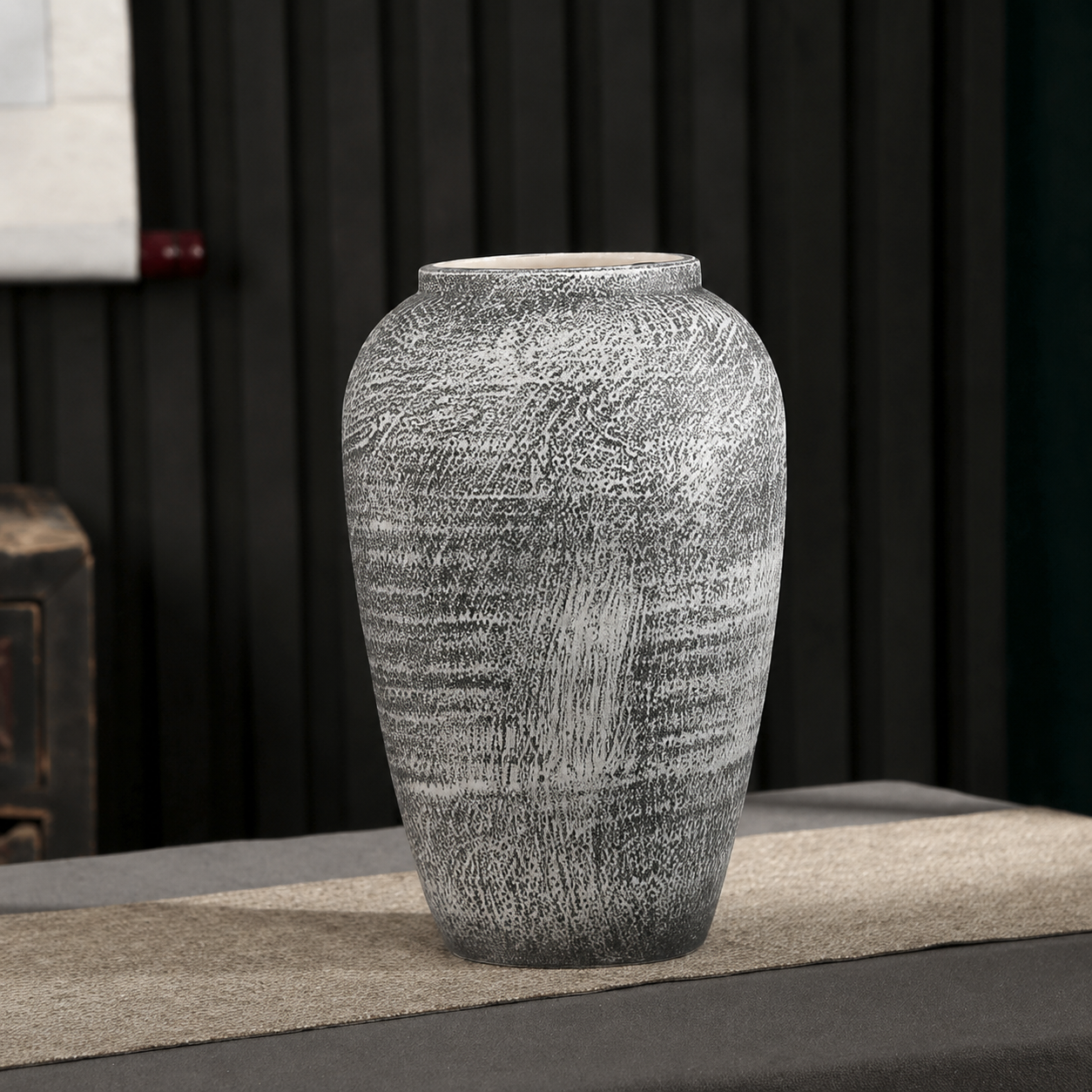Medium textured gray ceramic decorative vase in a dark modern interior
