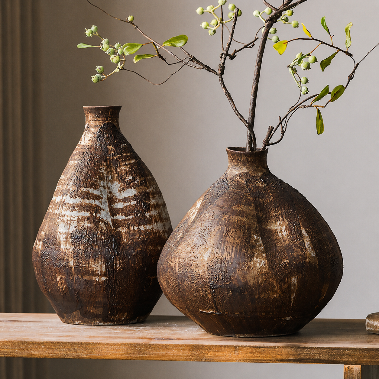 Short and medium rustic brown ceramic vases styled with green leafy branches