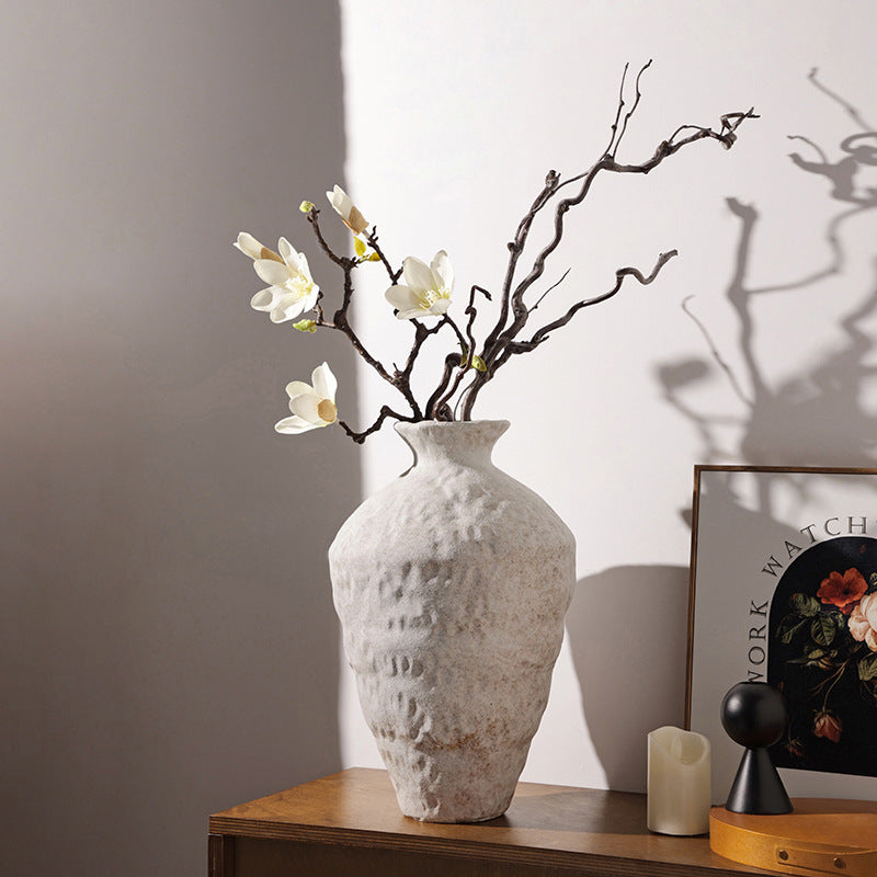 Textured ceramic vase with white flowers styled in a warm modern interior