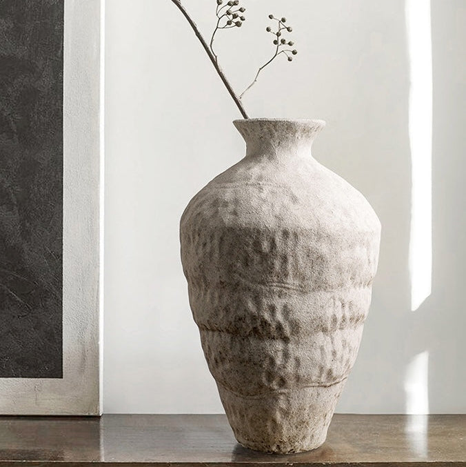 Tall Wabi Sabi textured ceramic vase with branches beside a softly lit window