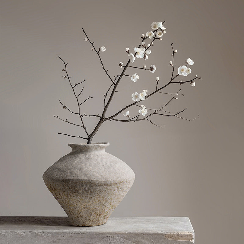 Small rustic ceramic Wabi Sabi vase styled with bare branches on a neutral shelf