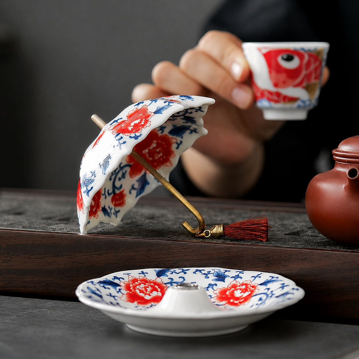 Ceramic tea strainer laid on its side beside a matching drip tray during tea service