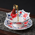 Scalloped red and blue floral ceramic tea strainer with matching drip tray and gold handle