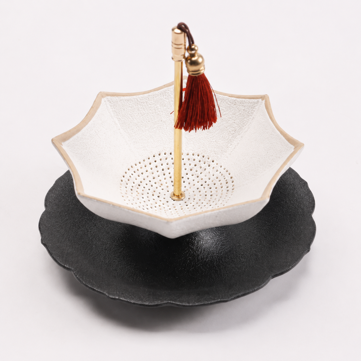 White and black scalloped ceramic tea strainer with matching drip tray