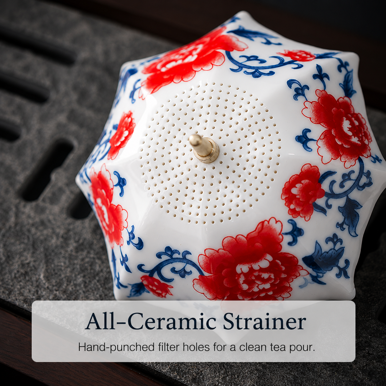 Close-up of all-ceramic perforated tea strainer holes in red and blue floral design
