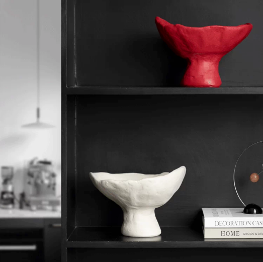 Red and white sculptural ceramic pedestal bowls displayed as modern decor