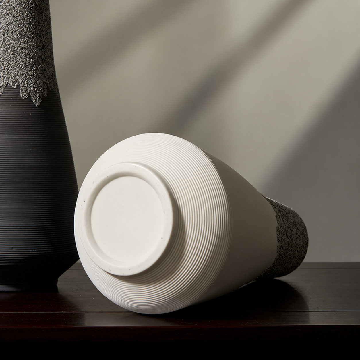 White ceramic vase shown on its side with finished circular base