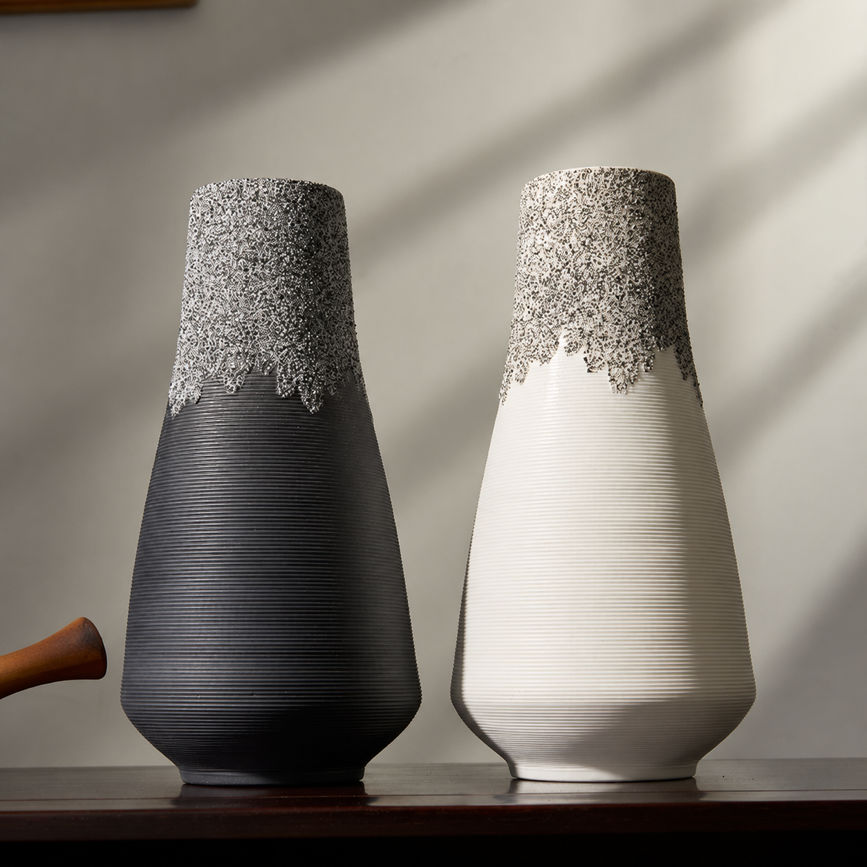 Black and white textured ceramic vases displayed together in natural light
