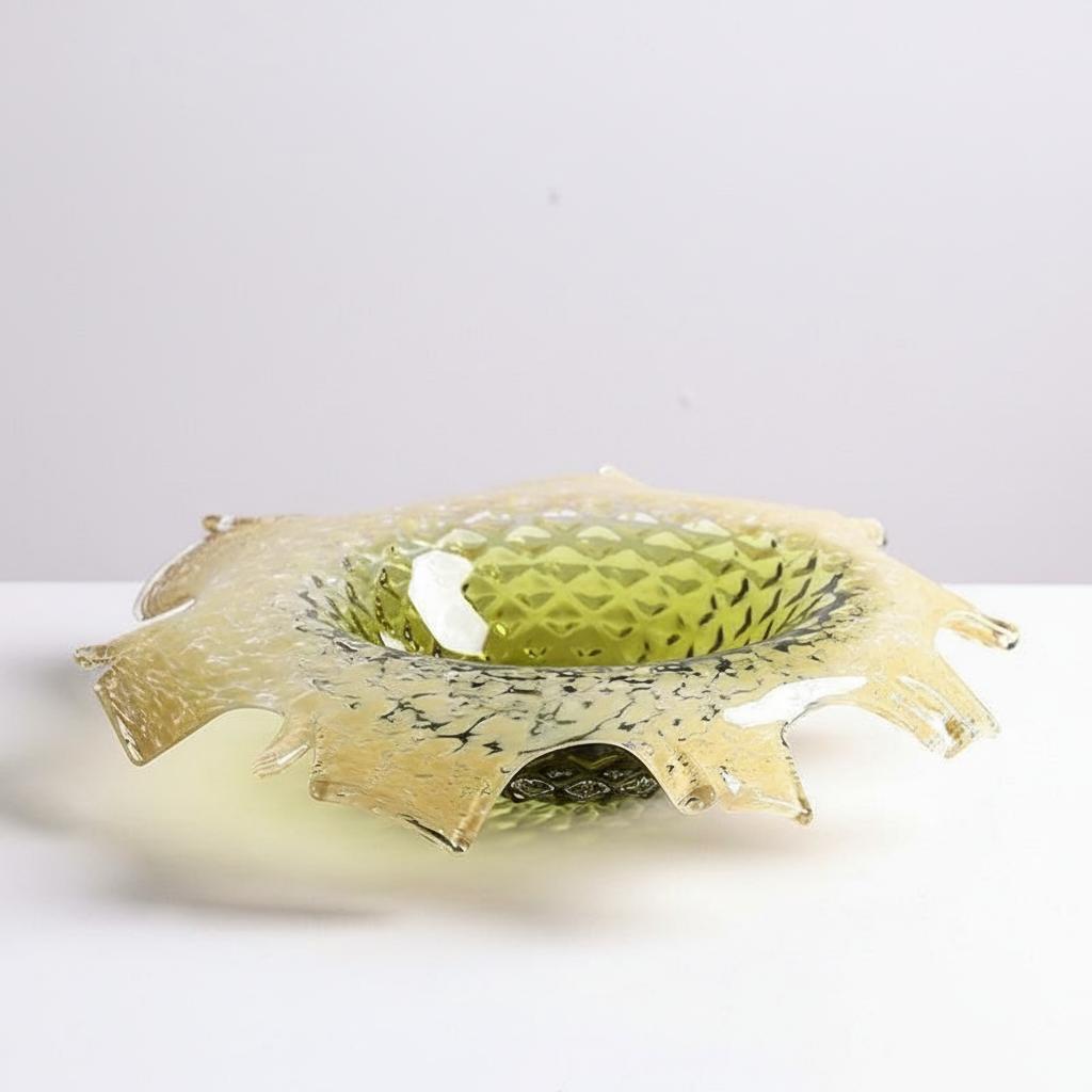 Low faceted glass centerpiece bowl with organic ruffled rim in amber green gradient
