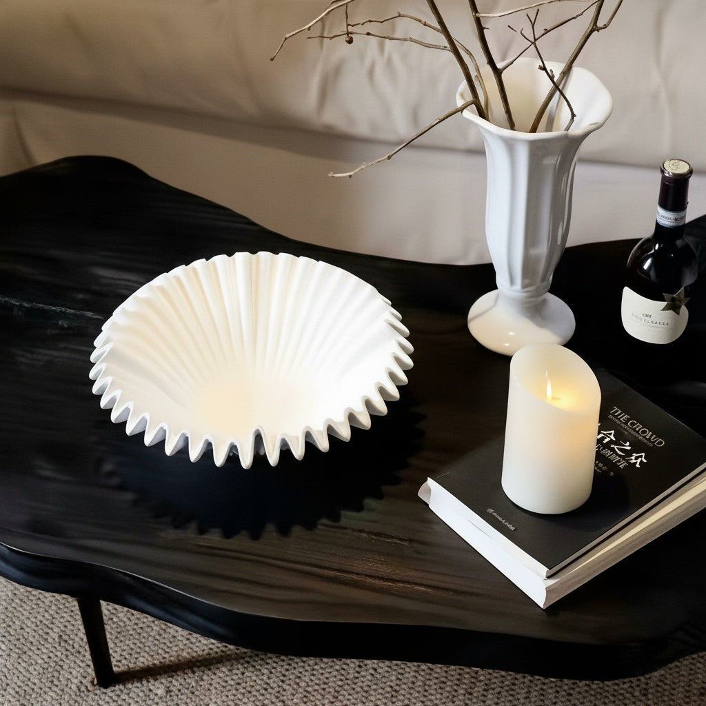 White sculptural resin centerpiece bowl styled on black coffee table
