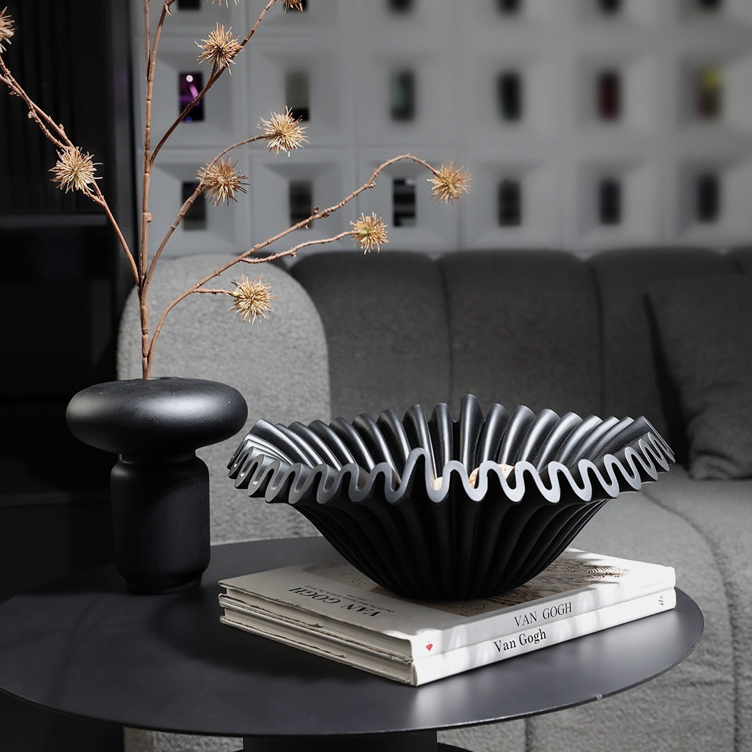 Black ruffled resin centerpiece bowl displayed in dark modern interior