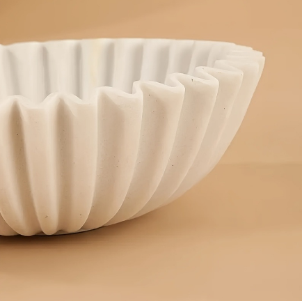 Close up of sandstone fluted resin bowl showing sculptural ribbed texture