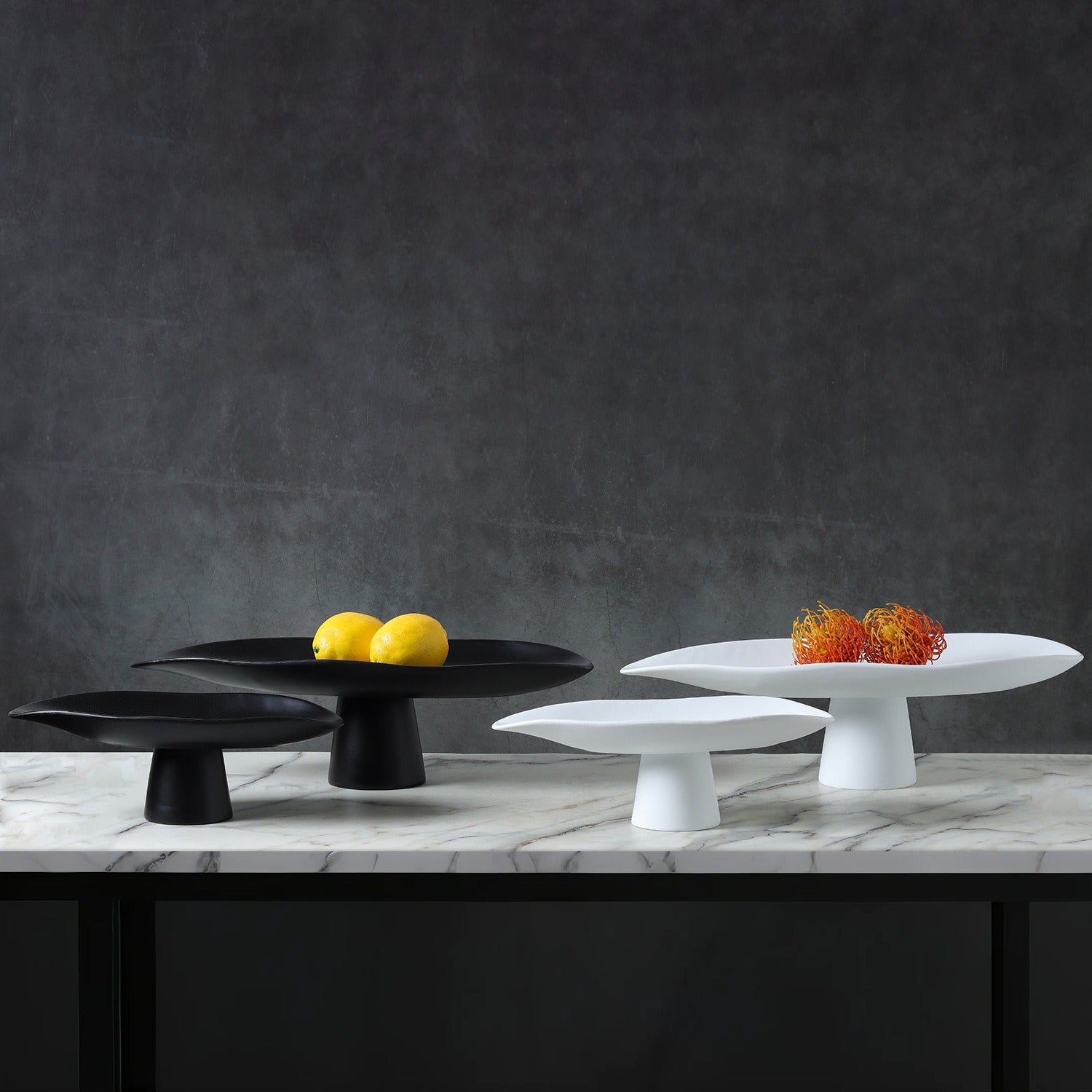 Black and white sculptural resin centerpiece bowls styled with lemons and decorative accents
