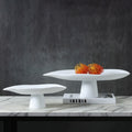 White and black sculptural resin pedestal bowls displayed together with decorative accents