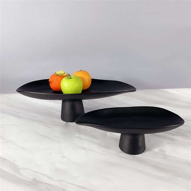 Black resin pedestal centerpiece bowls styled with colorful fruit on marble tabletop