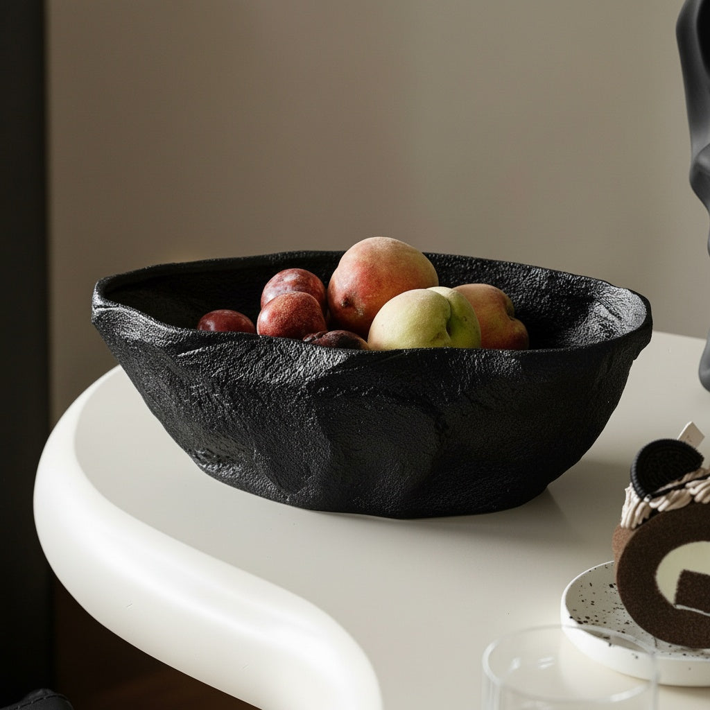 Black sculptural textured ceramic centerpiece bowl filled with fruit on modern white table