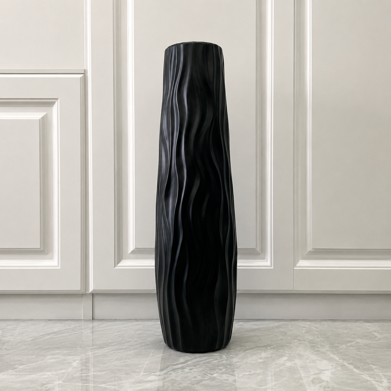 Black sculptural wavy textured floor vase displayed in a minimalist interior