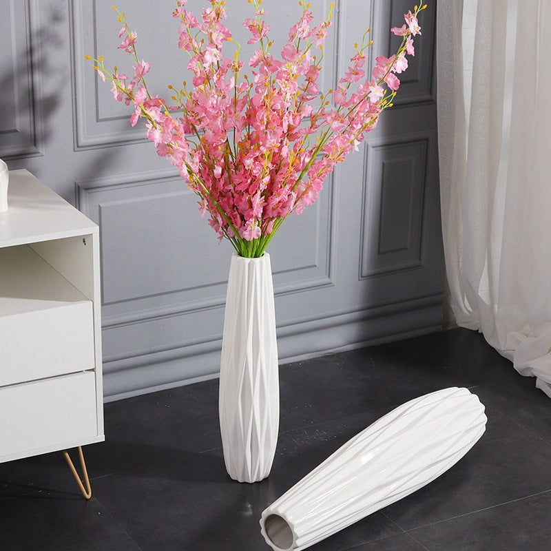 White textured floor vase styled with pink flowering branches beside a coordinating vase