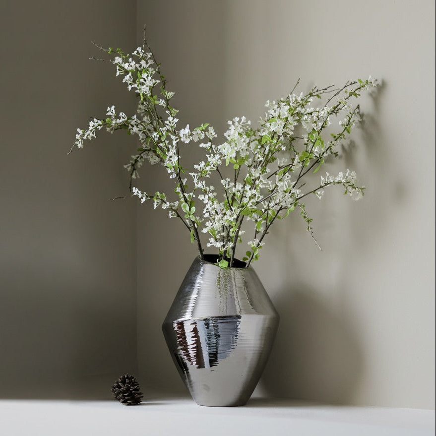 Silver ceramic vases with reflective metallic finish displayed on shelf