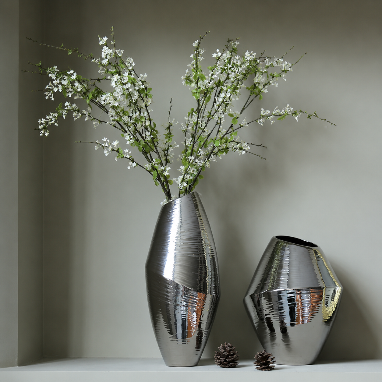 Silver ceramic vases with white flowers styled in modern home decor setting