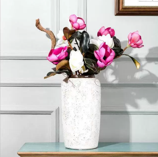 Speckled ceramic flower vase with bronze rim styled with pink and white magnolia stems