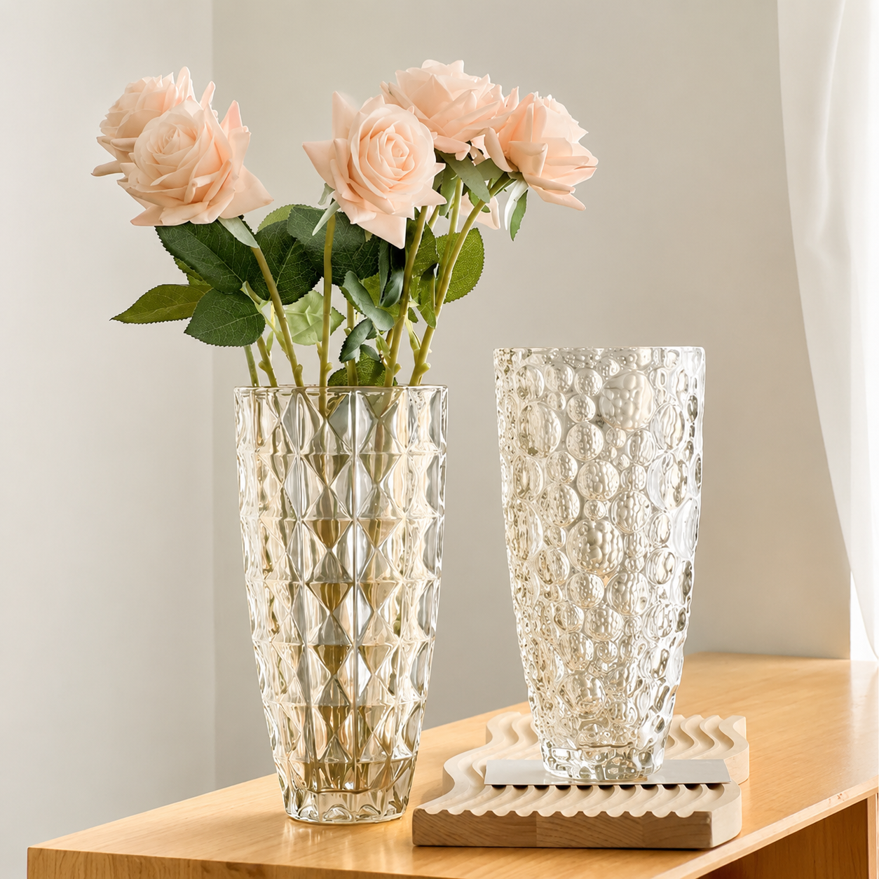 Diamond and bubble textured glass flower vases styled with pale pink roses on a wooden console
