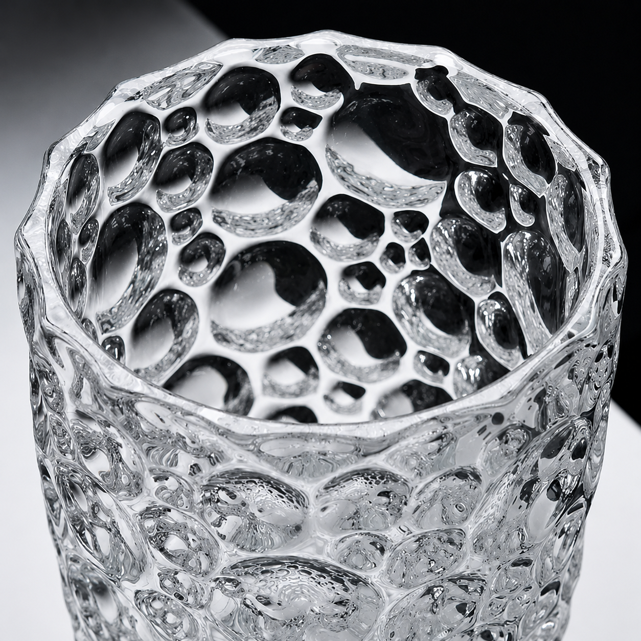 Close up of the opening and thick rim of a clear bubble textured glass vase
