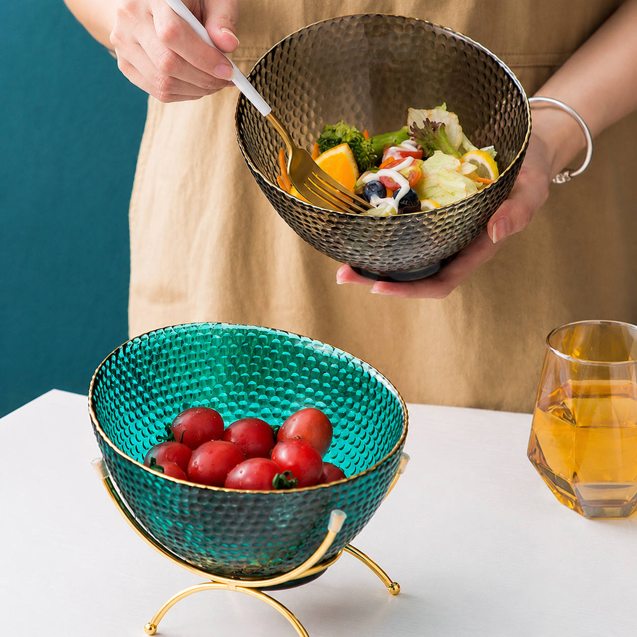 Teal glass fruit bowl with stand and smoke gray salad bowl in lifestyle setting