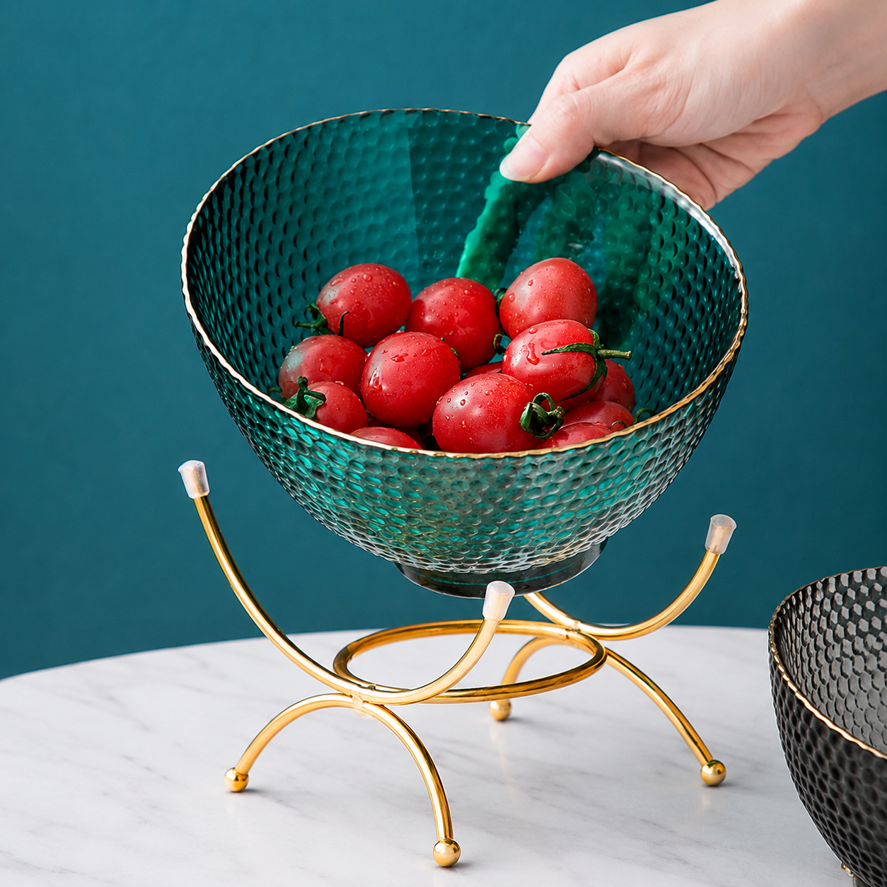 Teal textured glass fruit bowl with gold stand filled with cherry tomatoes
