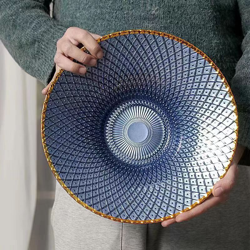 Blue flared textured glass centerpiece bowl with gold rim held in hand