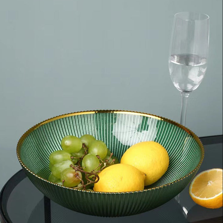 Green round glass centerpiece bowl with grapes and lemons on glass side table