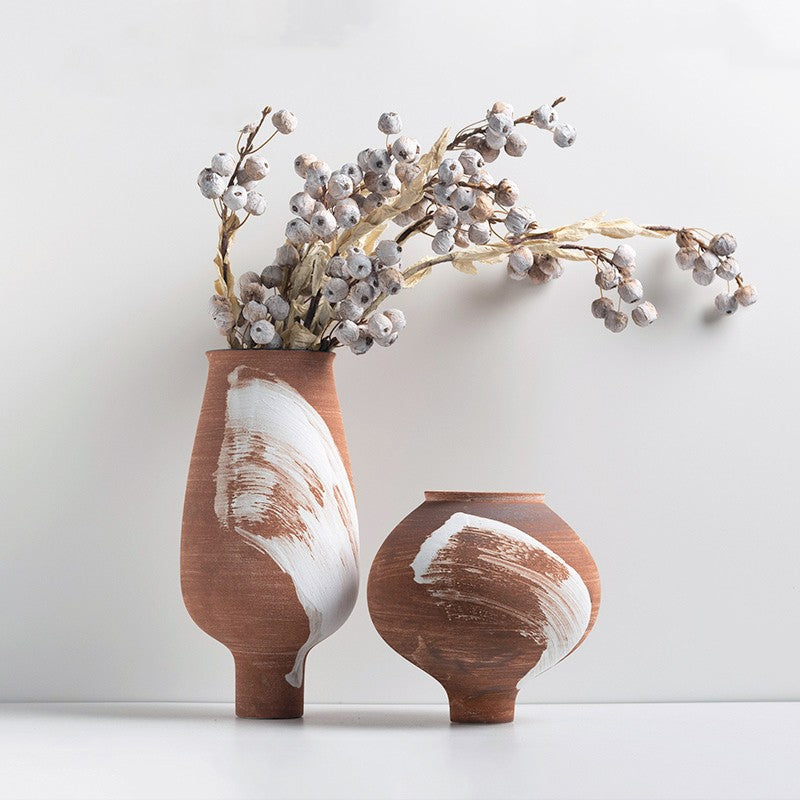 Tall and short terracotta ceramic vases with dried branches and white brushstroke accents