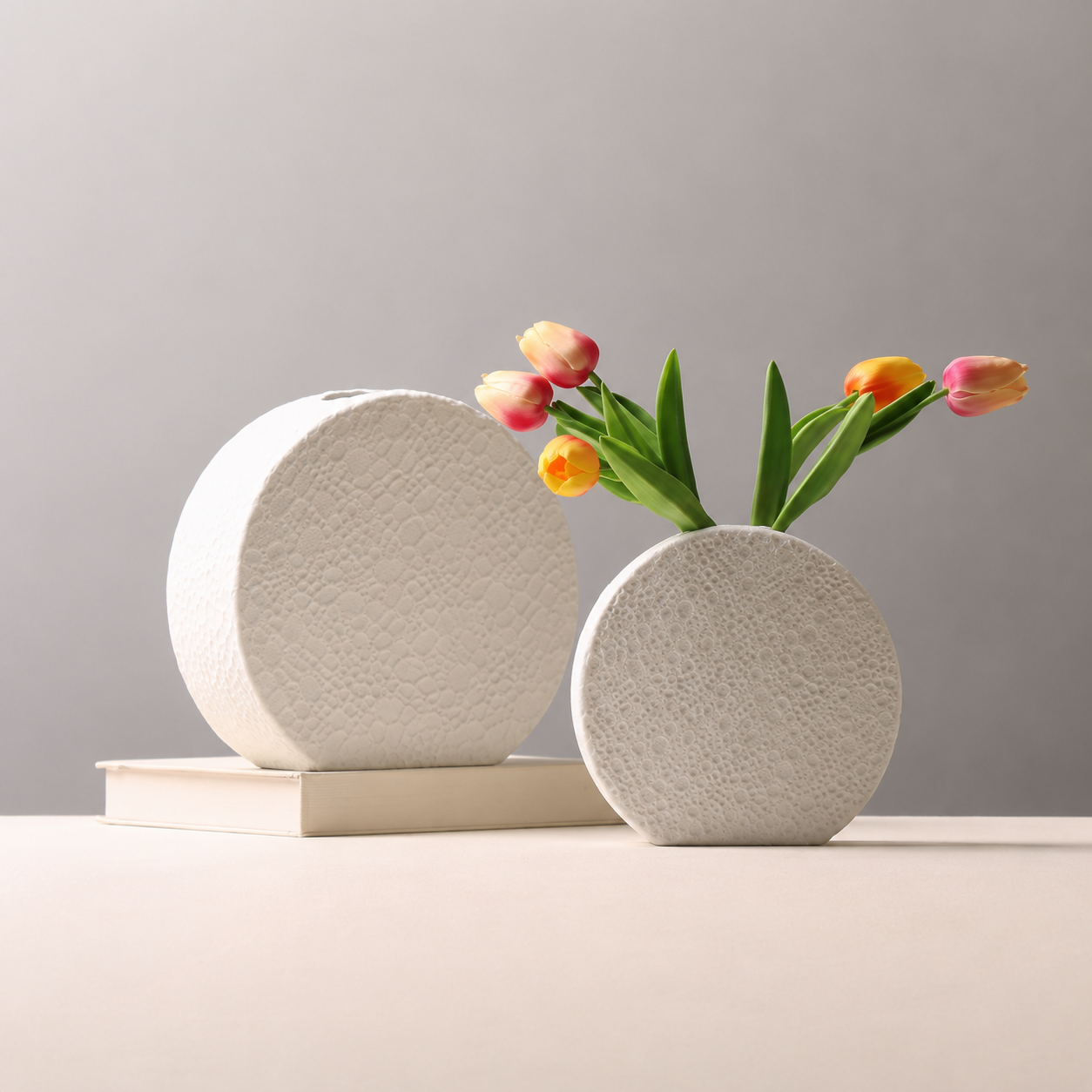 Textured white ceramic round vases with tulips in a minimalist setting