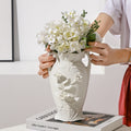 Vintage white ceramic flower vase with raised floral relief styled with white hydrangeas