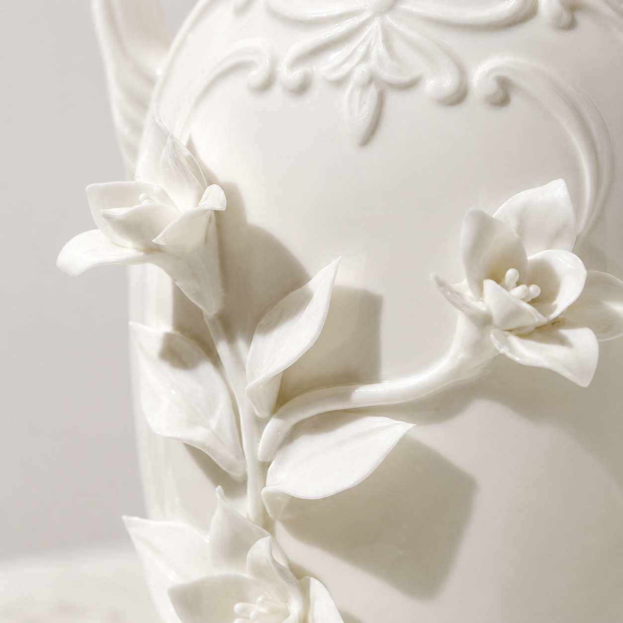 Close-up of raised floral relief on vintage white ceramic vase