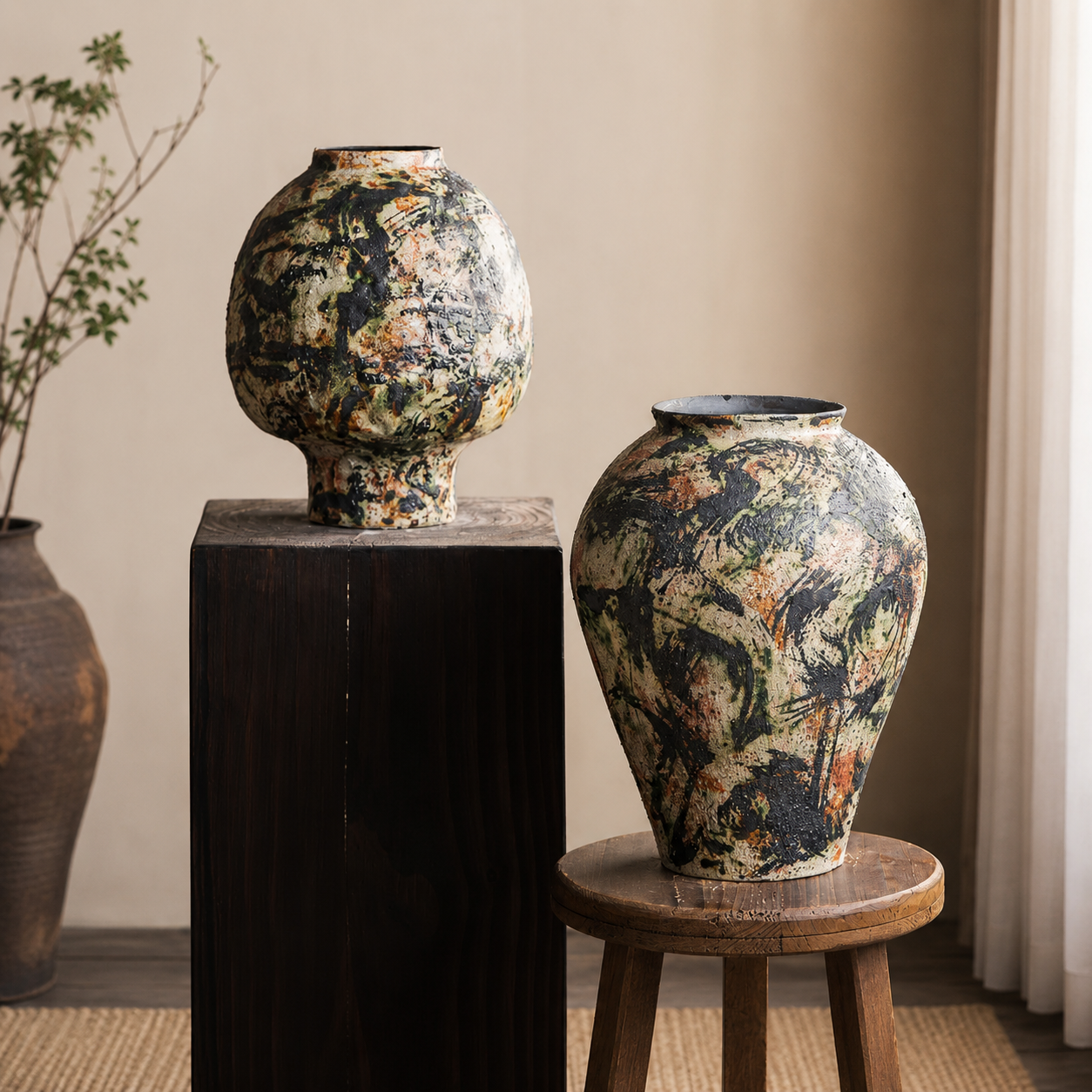Two abstract glazed ceramic vases displayed on wooden stands in a neutral interior