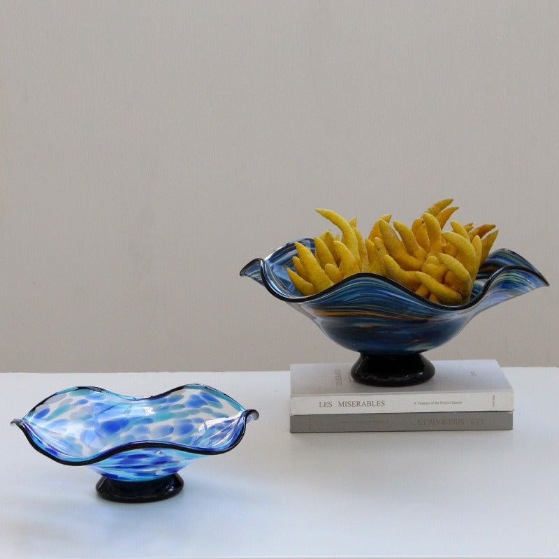 Light blue and blue wavy art glass centerpiece bowls styled together with decorative fruit